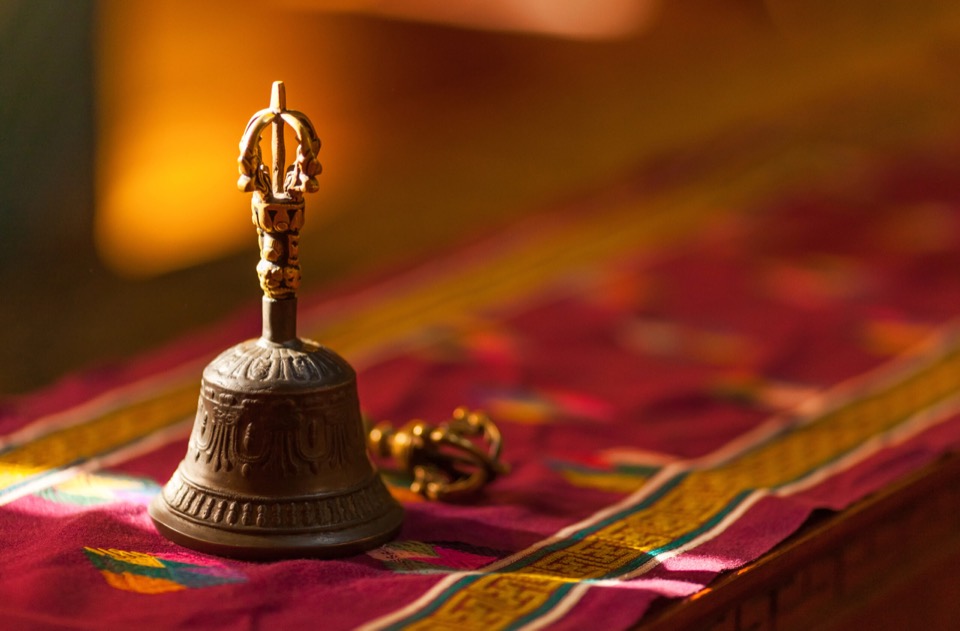 A Tibetan ritual bell and vajra on a brocade cloth
